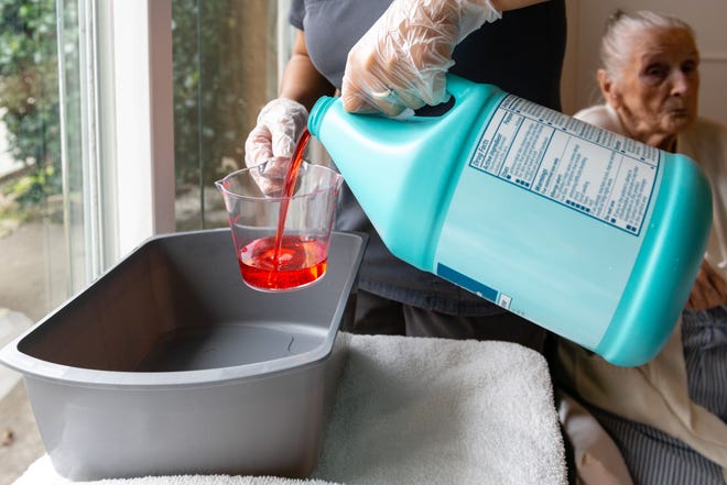 Certified nursing assistant Cristina Zainos prepares a special wash using antimicrobial soap. [Photos by Heidi de Marco/KHN]