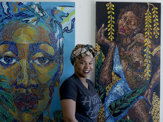 Artist Tracy Guiteau, inside of her studio in Greenacres, standing in front of some paintings, all of which are inspired by womanhood and Haitian culture. 

Left: "Madame" 36x48, acrylic on canvas

Right: "Love Exposure" 48 by 24, acrylic on canvas. [WILKINE BRUTUS/palmbeachpost.com]