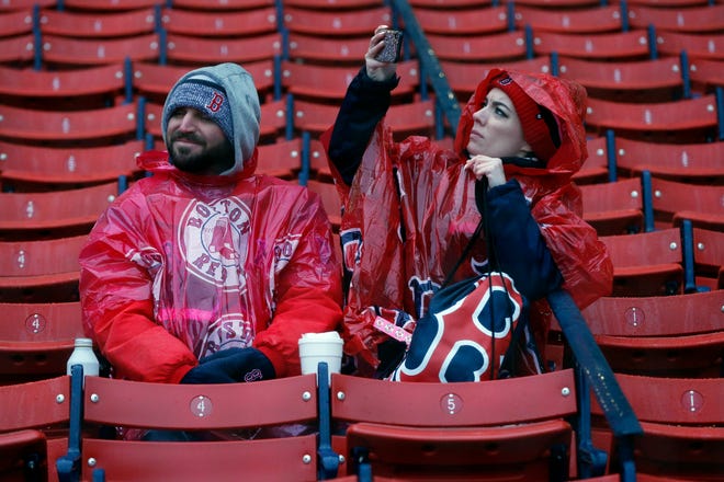 T.J. and Carolanne Parks, of New Orleans, wear rain gear at Fenway Park in Boston, Friday, April 26, 2019. The scheduled baseball game between the Boston Red Sox and the Tampa Bay Rays was postponed due to inclement weather. (AP Photo/Michael Dwyer)