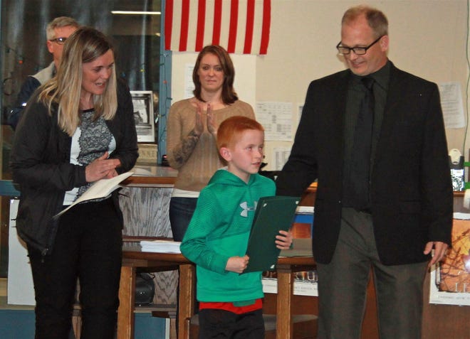 Clinton Elementary School student of the month for March, Grady O'Malley, is congratulated Monday night by Vice Principal Meaghan Silvio and Principal Robert Rouleau. [Item photo/JAN GOTTESMAN]
