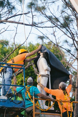 Workers position the top of the Confederate monument in its new location at Veterans Memorial Park in Lakeland on March 29. [LAURA L. DAVIS/THE LEDGER]