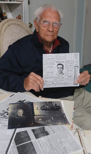 Akron resident Joseph Ralph Agosta, 92, holds a 1930s newspaper article April 22 about arrests of the Baird Street bootlegging gang. [Phil Masturzo/Beacon Journal/Ohio.com]
