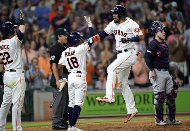 Houston Astros base runner Robinson Chirinos, center, celebrates with Tony Kemp and Josh Reddick, left after hitting a three-run home run as Indians catcher Roberto Perez, right, stands at home plate during the seventh inning Sunday in Houston. [David J. Phillip/The Associated Press]