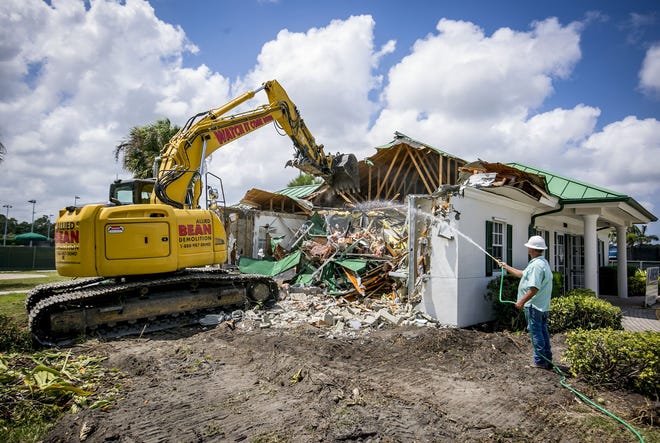 Crews demolish the old Palm Beach Gardens tennis center clubhouse Monday on 117th Court North. A new, two-story clubhouse that is more than six times the size of the old one will be built in its place. [RICHARD GRAULICH/palmbeachpost.com]