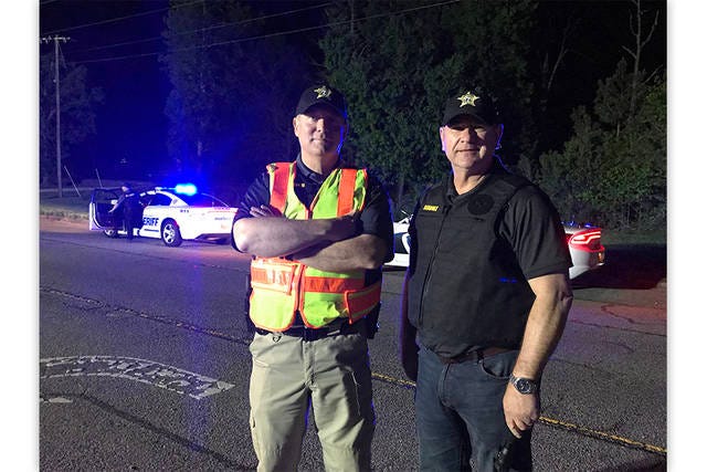 Lt. Col. Steve Myers and Sheriff Greg Seabolt monitor a license checkpoint on U.S. 311 near Archdale late Saturday night. (Jamie Biggs / The Courier-Tribune)