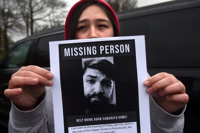 Alison Martell holds up a picture of her brother, Adam Camarato, of Eliot, Maine, who has been missing since early Saturday morning, when he was last seen leaving Clipper Tavern in Portsmouth. Family and friends gathered Tuesday in Portsmouth to distribute flyers and knock on doors in hopes of finding surveillance footage or any leads that could help police find him. [Deb Cram/Seacoastonline and Fosters.com]