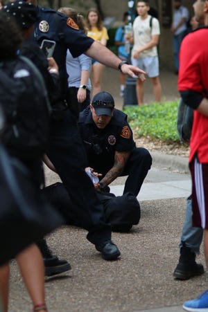 Texas State University police arrest a masked student protester Wednesday outside the campus police department headquarters. [CHINEDU CHUKUKA/THE UNIVERSITY STAR]