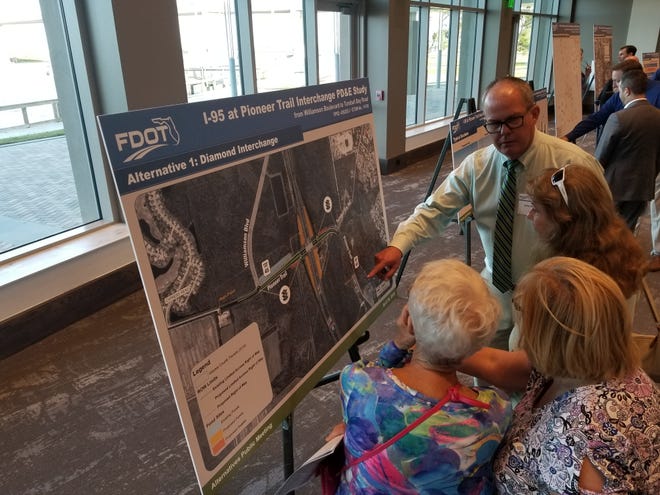 Attendees eye one of the options to build an interchange at Interstate 95 and Pioneer Trail as they listen to a representative of the Florida Department of Transportation answer questions about the project. [News-Journal/Casmira Harrison]