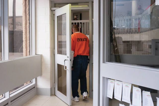 An inmate is seen entering one of the housing units at Joseph Harp Correctional Facility in Lexington. Whitney Bryen/ Oklahoma Watch
