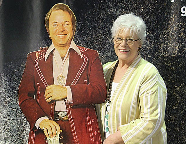 Barbara Clark, at right, stands with a life-size cutout of her late husband, Roy, prior to the opening of the Roy Clark Memorial Championship Rodeo last Friday at the fairgrounds in Pawhuska. Robert Smith/Journal-Capital