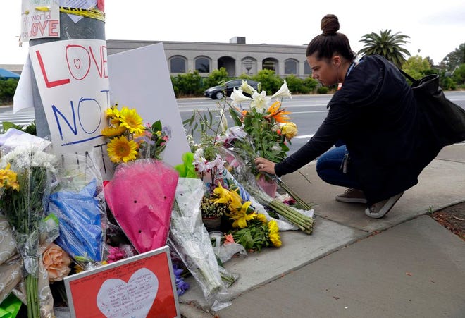 A woman leaves flowers on a memorial across the street from the Chabad of Poway synagogue in Poway, Calif., on Monday, April 29, 2019. A gunman opened fire on Saturday, April 27 as dozens of people were worshipping exactly six months after a mass shooting in a Pittsburgh synagogue. [Greg Bull/The Associated Press]