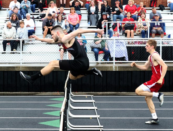 New Phila's Jacob Finnicum captured the 300 hurdles in a time of 42.77 as the Quakers needed every point they could get as they squeeked by their archrival Thursday night at Woody Hayes Quaker Stadium. (TimesReporter.com / Jim Cummings)