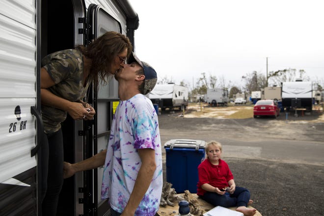 Holly Johnson kisses Chris Brockman before he drives to pick up their daughter Kaelee Johnson, 11, while their daughter Kaydee Johnson, 9, groans at their trailer provided by FEMA on Feb. 20, 2019. Because of problems with busing, Brockman spends much of his day shuttling their children back and forth to school. [JOSHUA BOUCHER/THE NEWS HERALD]
