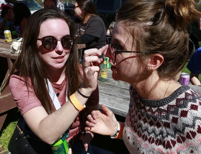 Julia Miggins, left, helps Courtney Ray Goodson apply sunscreen during an event at South by Southwest in Austin, Texas. [STEPHEN SPILLMAN/FOR AUSTIN AMERICAN-STATESMAN]