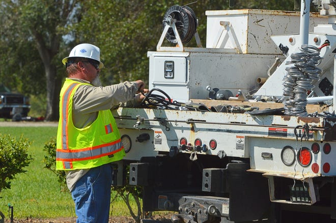 Workers repair electric lines damaged by Hurricane Irma along Fish Camp Road in Grand Island on Sept. 19, 2017. [Whitney Lehnecker / Daily Commercial]