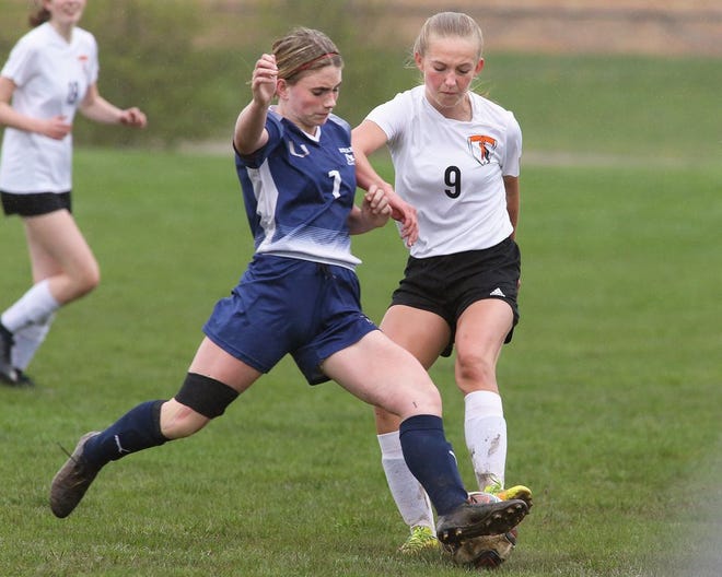Adrian High School’s Brooke Patterson (left) and Tecumseh’s Bailey Fraker, battle for possession of the soccer ball during Thursday’s Southeastern Conference matchup played in Adrian on a muddy and wet field.