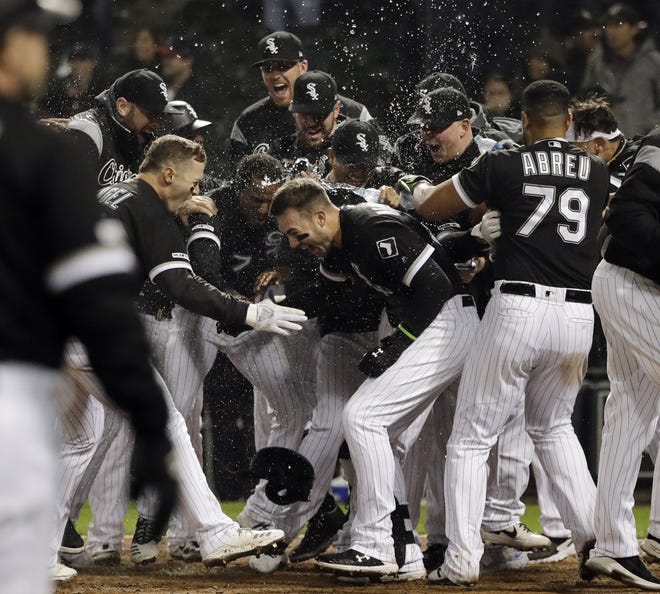 The White Sox's Nicky Delmonico, center, is congratulated by teammates after hitting the game-winning home run in the bottom of the ninth inning of his team's 6-4 victory over the Red Sox Thursday night in Chicago. [NAM Y. HUH/THE ASSOCIATED PRESS]