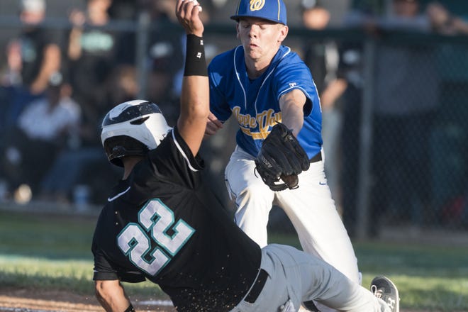 Sultana's Dominic Arellano slides under Apple Valley Christian's Jerrett Jackson during a CIF-Southern Section playoff game at Sultana on Friday. The Sultans won to advance to the second round of the CIF-Southern Section Division 6 playoffs. [James Quigg, Daily Press]
