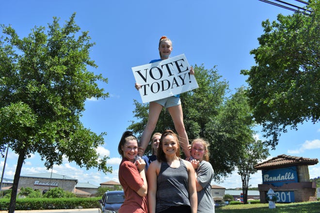 Acrobat athletes cheer on voters in front of Randalls in Lakeway on Saturday. [LESLEE BASSMAN FOR STATESMAN]