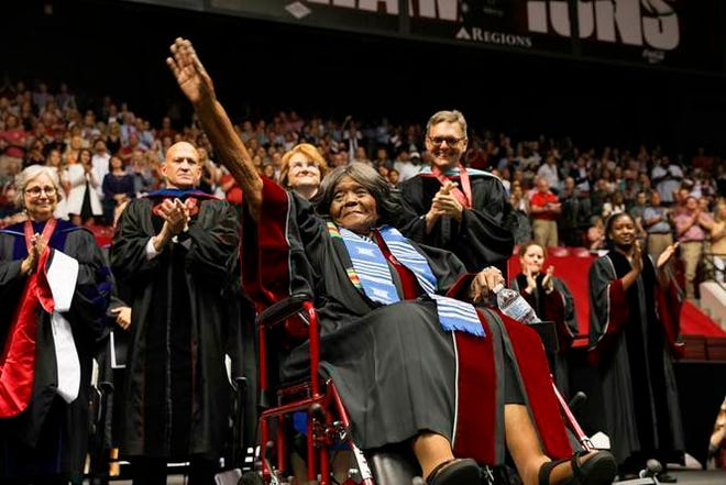 Autherine Lucy Foster acknowledges the crowd as she receives a an honorary doctoral degree during a commencement exercise at The University of Alabama on Friday in Tuscaloosa, Ala. The university bestowed the honorary doctorate degree to Foster, the first African American to attend the university. [Zach Riggins/UA Strategic Communications via AP]