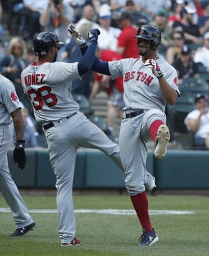 The Red Sox' Xander Bogaerts, right, celebrates his grand slam with teammate Eduardo Nunez during the eighth inning of Sunday's game against the White Sox in Chicago . [AP / Jeff Haynes]