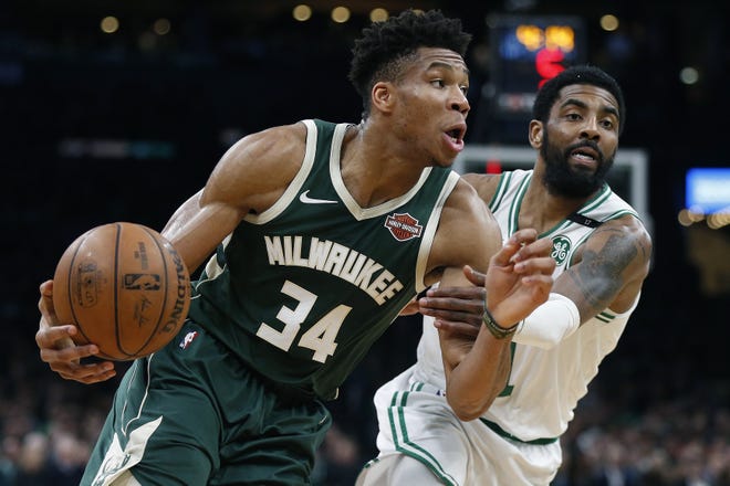 Milwaukee Bucks' Giannis Antetokounmpo (left) drives past Boston Celtics' Kyrie Irving during the first half of Game 3 on Friday. [AP File Photo/Michael Dwyer]