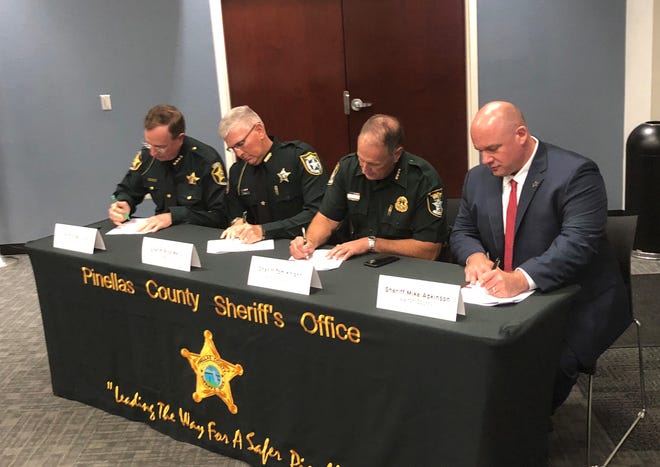 Sheriff Tom Knight (second from right) signs Warrant Service Officer Agreement along with Polk County Sheriff Grady Judd (left), Manatee County Sheriff Rick Wells (second from left), and Walton County Sheriff Mike Adkinson (right). [COURTESY SARASOTA COUNTY SHERIFF'S OFFICE]