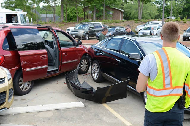 AFTERMATH — A firefighter with the Asheboro Fire Department surveys damages after a driver struck four cars in the Asheboro Post Office parking lot Monday afternoon. (Scott Pelkey / The Courier-Tribune)