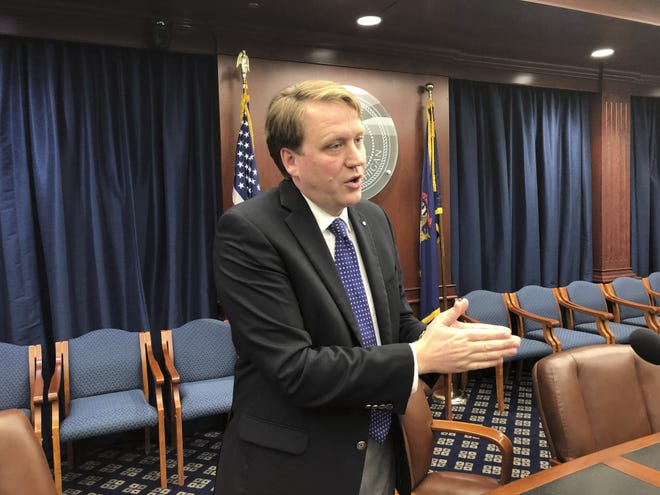 Sen. Aric Nesbitt, a Lawton Republican, speaks with reporters following a Senate committee's party-line vote in favor of his bill that would end a requirement that drivers have unlimited medical coverage through their car insurer on Tuesday, May 7, 2019, in Lansing, Mich. Nesbitt says health costs are driving high auto insurance rates in the state. (AP Photo/David Eggert)