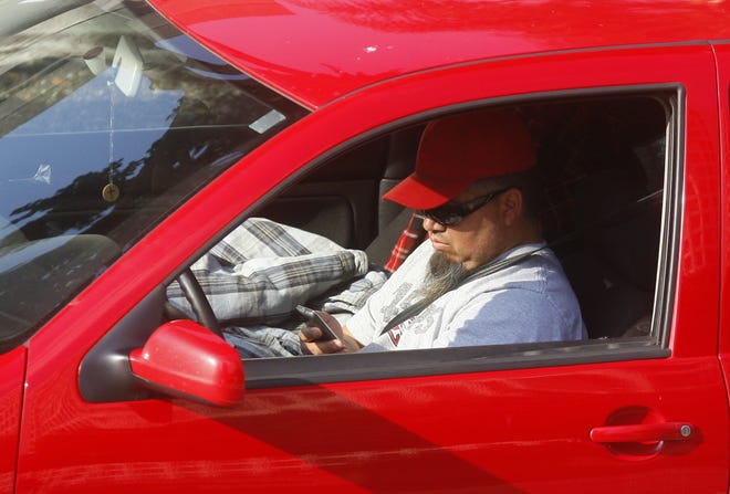 A driver uses a cellphone while driving in Los Angeles. A new Florida law makes texting (including messaging, emailing and other forms of typing on a mobile device) a primary violation, rather than a secondary violation. [DAMIAN DOVARGANES/THE ASSOCIATED PRESS (FILE)]
