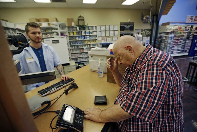 Russ Schmidt, 74, picks up his wife's prescription drugs from a pharmacy. Schmidt, who retired 10 years earlier, said he became an Uber driver after his wife's hospitalization and uses the money to help pay for her medication. [AP Photo/Rick Bowmer, File]