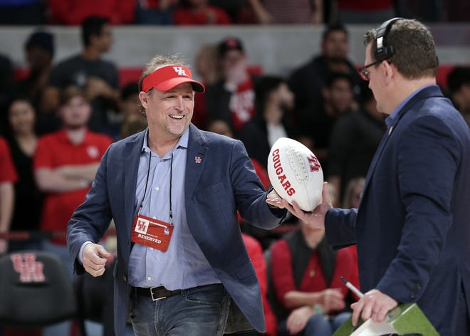 New Houston college football coach Dana Holgorsen get an autographed football to toss to fans during halftime of a basketball game between Houston and Tulsa on Jan. 2 in Houston. [AP Photo/Michael Wyke, File]