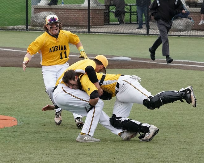 Adrian College catcher Gunner Rainey tackles Dugan Darnell after clinching the MIAA regular season championship against Hope.