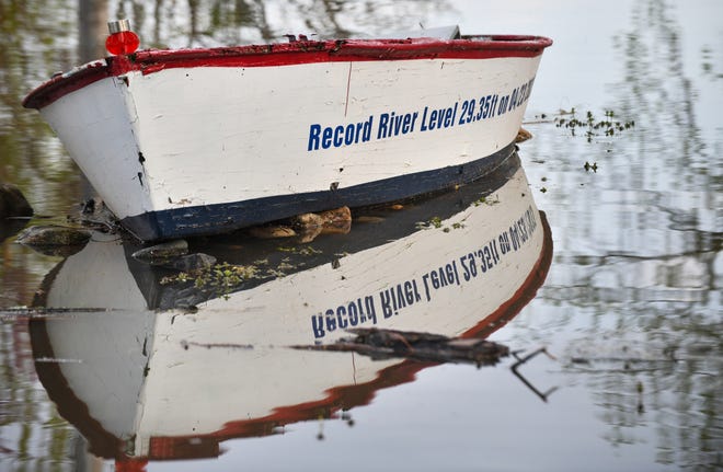 RON JOHNSON/JOUNRAL STAR The writing on the side of a rowboat records the high water mark set in 2013 of 29.35 feet, as the current level on Monday reached 28 feet along North River Beach Road.