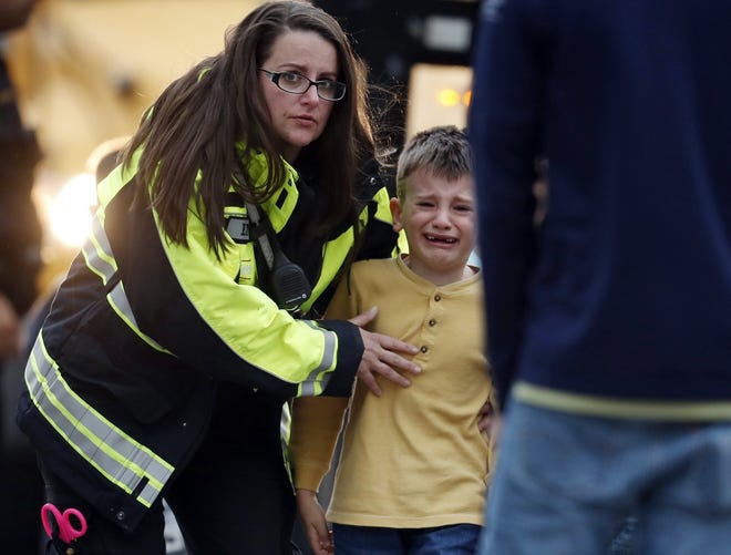 Officials guide students off a bus and into a recreation center where they were reunited with their parents after a shooting at a suburban Denver middle school Tuesday in Highlands Ranch, Colo. [AP Photo/David Zalubowski]