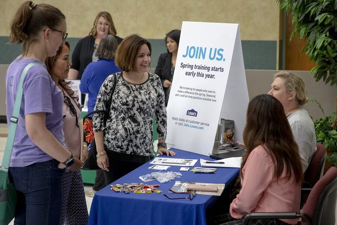 Jenny Villarreal, center, a teaching assistant at Whitestone Elementary in Leander, speaks to Lowe's representatives Wednesday during a job fair organized by the Leander school district. The event was set up to match district employees with employers seeking seasonal help. [NICK WAGNER/AMERICAN-STATESMAN]