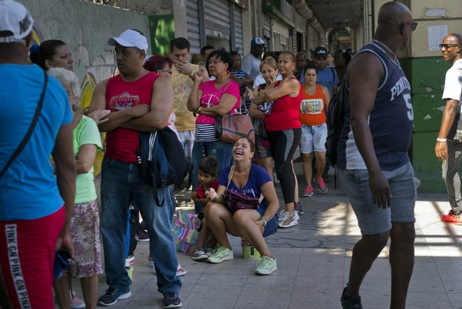 People wait in line to buy chicken at a government-run grocery store in Havana, Cuba. The Cuban government said Friday that it will begin widespread rationing of chicken, eggs, rice, beans, soap and other basic products in the face of a grave economic crisis. [RAMON ESPINOSA/THE ASSOCIATED PRESS]