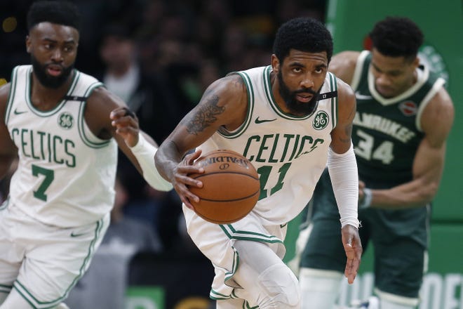 Boston Celtics' Kyrie Irving (right) brings the ball up court during the second half of Game 4 in their loss to the Bucks. Irving's future in Boston remains uncertain. [AP File Photo/Michael Dwyer]