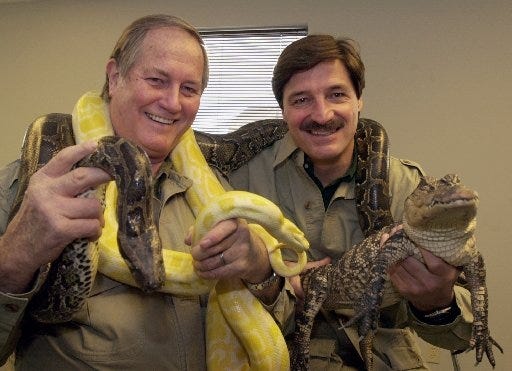 Mutual of Omaha's Jim Fowler, left, and Peter Gros, are seen in 2002 in Omaha, Neb., holding two pythons and an alligator. (AP Photo/Nati Harnik)
