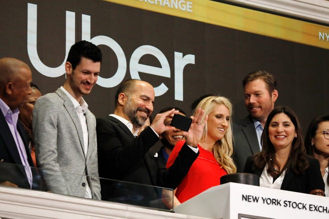 Uber CEO Dara Khosrowshahi, third from left, takes a photograph as he attends the opening bell ceremony at the New York Stock Exchange, as his company makes its initial public offering, Friday, May 10, 2019. (AP Photo/Richard Drew)