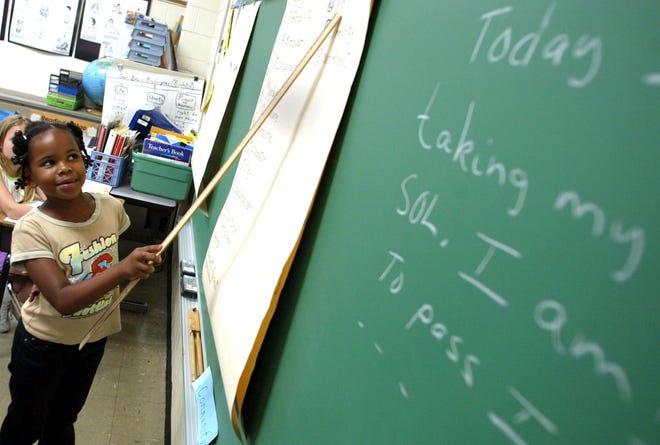 A 9-year-old girl points to the chalkboard during a lesson on reading. [AP Photo/Jason Hirschfeld, File]