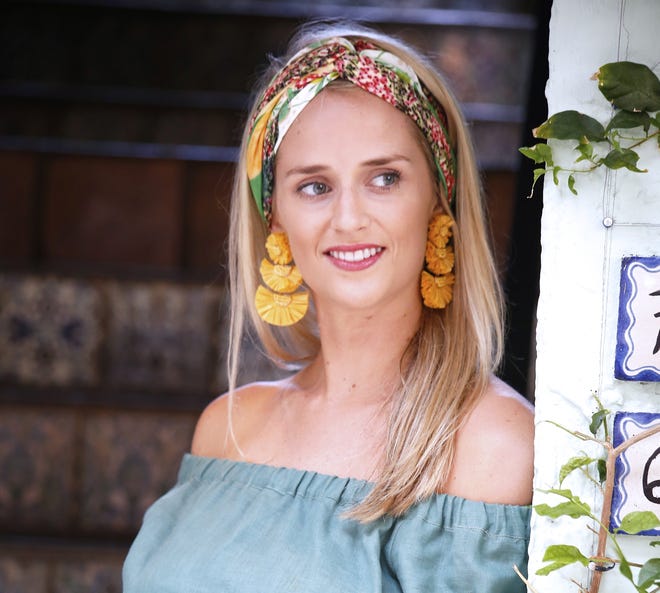 Palm Beacher and designer Olivia Meyer of Banniere shows the various ways her silk scarves can be worn. This boho chic look was pulled together with the Palm Beach "Green" design worn as an infinity headband. A bold and colorful earring turns the eyes toward the face. [Carla Trivino/palmbeachdailynews.com]