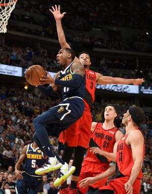 Portland guard CJ McCollum leaps to defend a shot by Denver's Monte Morris with Zach Collins (33) and Seth Curry (31) trailing in the first half of Sunday's Game 7 NBA playoff game in Denver. (AP Photo/John Leyba)