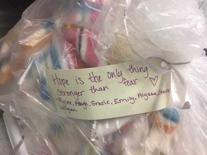 Students pinned tags with encouraging messages on the blankets they provided to the Alabama Cancer Care Center. They were inspired to do something for cancer patients after studying "The Last Lecture" by Randy Pausch, a professor who died of pancreatic cancer. [Donna Thornton/The Gadsden Times]