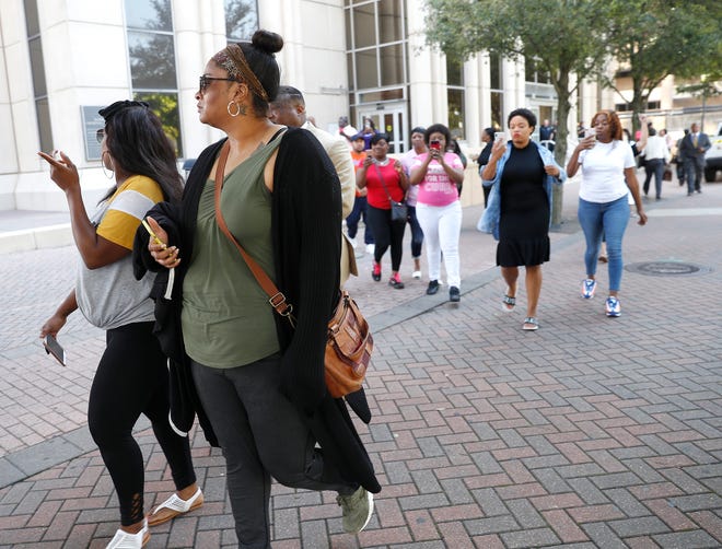 Brittany Bowens (foreground right), the mother of missing 4-year-old Meleah Davis, is followed down the street by protesters Monday after the court postponed a hearing for Derion Vence, who is charged with tampering with evidence in the case. [Karen Warren/Houston Chronicle]