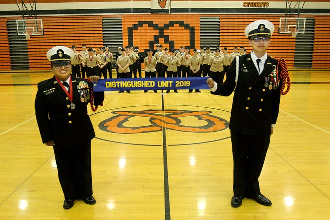 Araceli Matamoros, left, and Isaac Martinez hold the ribbon to announce that NJROTC was selected as the Distinguished Unit for 2019 during the Change of Command ceremony on Thursday, May 9, 2019, at Freeport High School in Freeport. [JANE LETHLEAN/THE JOURNAL-STANDARD CORRESPONDENT]