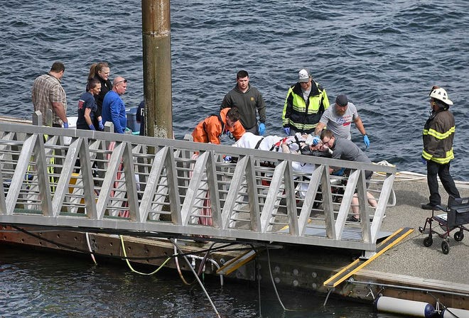 Emergency response crews transport an injured passenger to an ambulance at the George Inlet Lodge docks Monday in Ketchikan, Alaska. The passenger was from one of two float planes reported down in George Inlet early Monday afternoon and was dropped off by a U.S. Coast Guard 45-foot response boat.