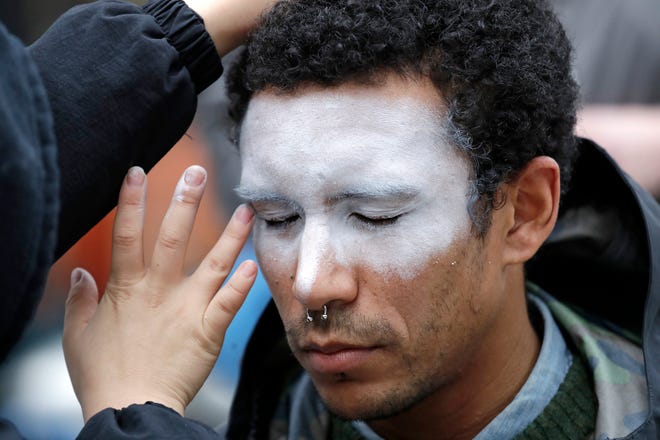FILE - In this Oct. 31, 2018, file photo, a man, who declined to be identified, has his face painted to represent efforts to defeat facial recognition during a protest at Amazon headquarters over the company's facial recognition system, "Rekognition," in Seattle. San Francisco is on track to become the first U.S. city to ban the use of facial recognition by police and other city agencies as the technology creeps increasingly into daily life. Studies have shown error rates in facial-analysis systems built by Amazon, IBM and Microsoft were far higher for darker-skinned women than lighter-skinned men. (AP Photo/Elaine Thompson, File)