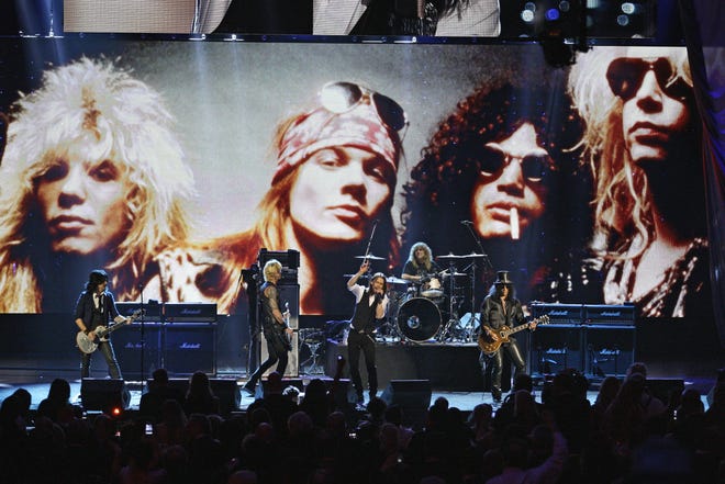 FILE - In this April 15, 2012, file photo, Guns N' Roses performs with singer Myles Kennedy after their induction into the Rock and Roll Hall of Fame in Cleveland. The rock band is accusing a Colorado brewery of stealing their brand and piggybacking off their fame to sell beer and merchandise. The band filed a trademark infringement lawsuit Thursday, May 9, 2019, against Colorado-based Oskar Blues Brewery, which sells Guns 'N' Ros‡© beer and merchandise, including bandannas the group says is uniquely associated with singer Axl Rose. (AP Photo/Tony Dejak, File)