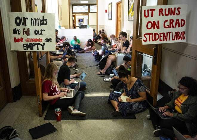 University of Texas graduate students grade papers and exams outside the office of Maurie McInnis, executive vice president and provost, on Monday to call attention to their demand for full tuition support. [RODOLFO GONZALEZ/FOR STATESMAN]